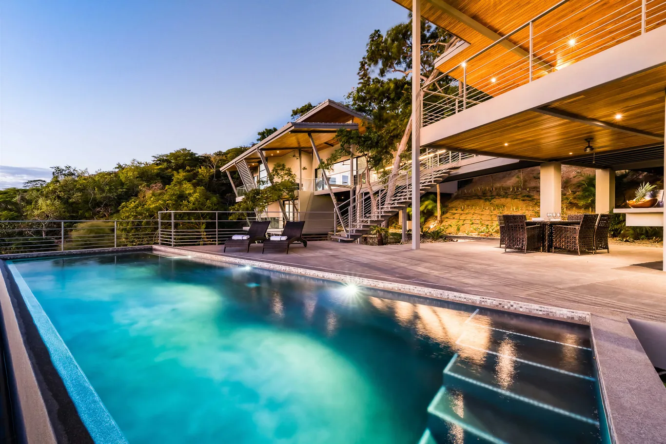 Pool terrace under a wood-lined roof at dusk